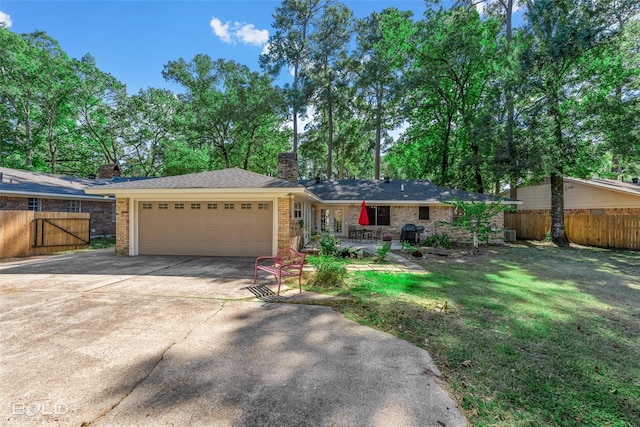 ranch-style home with a front yard, fence, a chimney, concrete driveway, and a garage