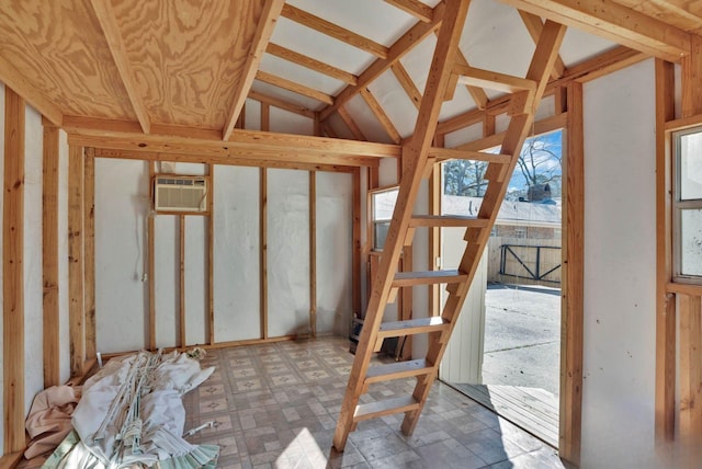 misc room featuring a wall unit AC, tile patterned floors, and lofted ceiling