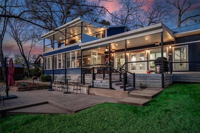 back of property featuring a balcony, a patio area, fence, and a sunroom