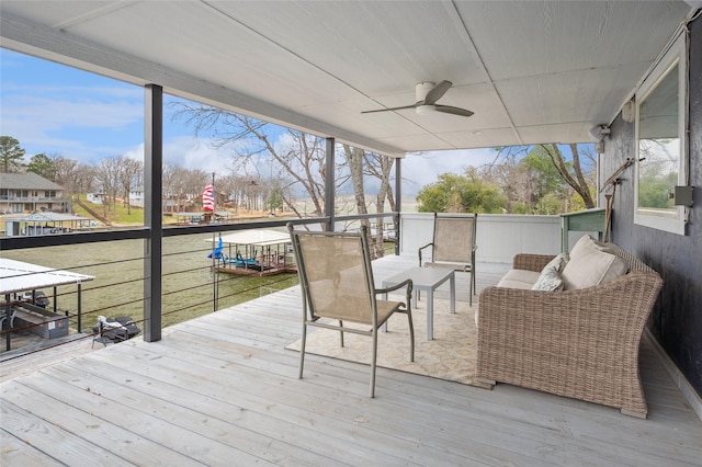 wooden terrace featuring a ceiling fan and an outdoor living space