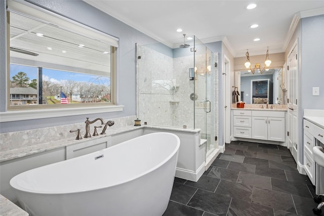 full bath with ornamental molding, a freestanding bath, a shower stall, and vanity