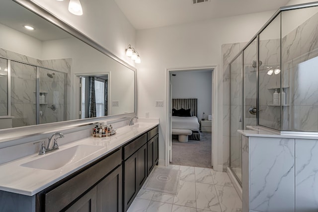 ensuite bathroom with marble finish floor, a marble finish shower, a sink, and ensuite bathroom