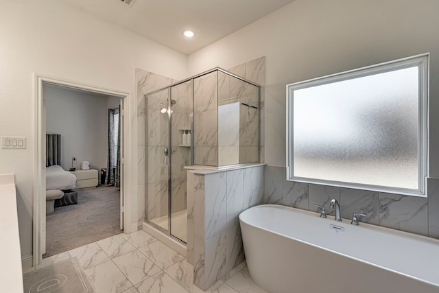 ensuite bathroom with marble finish floor, a marble finish shower, a freestanding bath, and recessed lighting