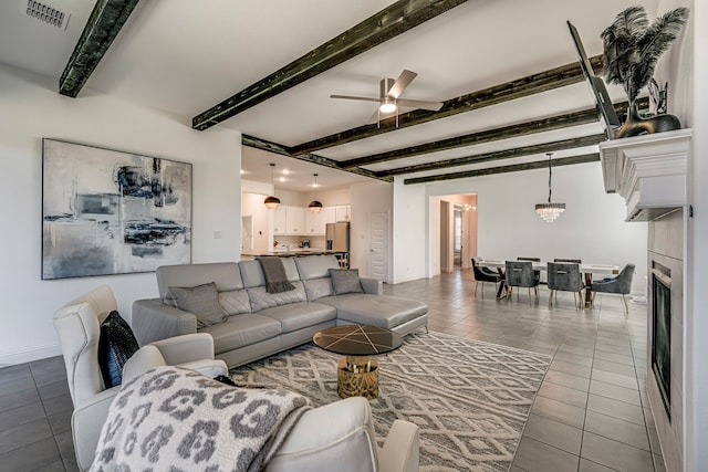 living room with tile patterned flooring, visible vents, beam ceiling, and ceiling fan with notable chandelier