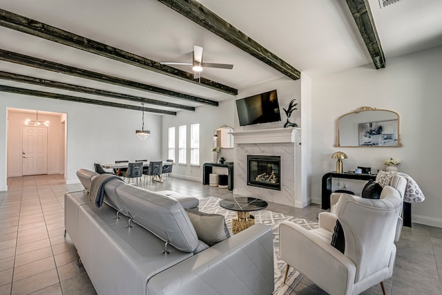 tiled living room with a fireplace, visible vents, beamed ceiling, baseboards, and ceiling fan with notable chandelier