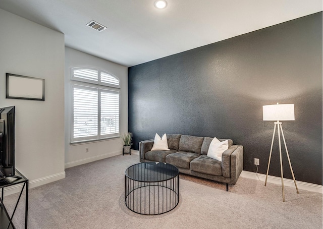 carpeted living room featuring baseboards and visible vents