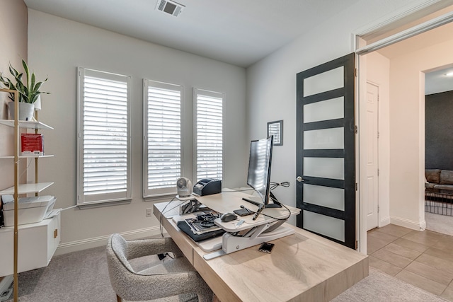 office featuring visible vents, light carpet, baseboards, and light tile patterned flooring