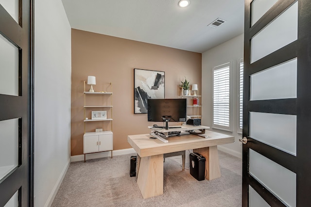 home office with baseboards, visible vents, and light colored carpet