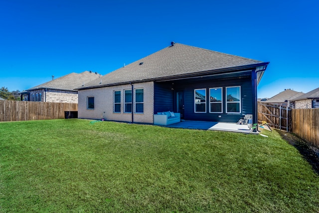 rear view of property featuring a fenced backyard, a patio, a lawn, and brick siding