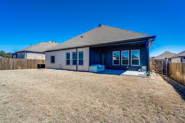 back of house with a yard, a fenced backyard, a patio, and brick siding