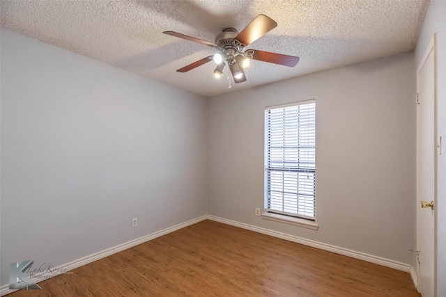 unfurnished room with a textured ceiling, wood finished floors, a ceiling fan, and baseboards