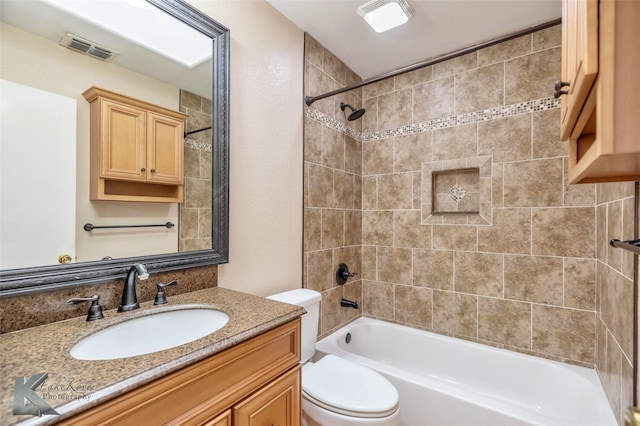 full bath with visible vents, vanity, toilet, and tub / shower combination