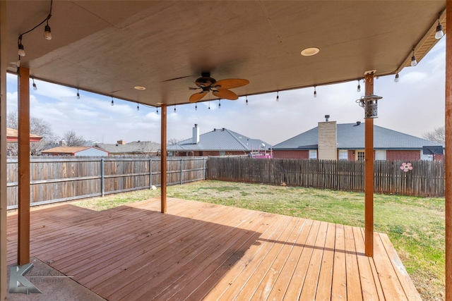 wooden terrace featuring a lawn, a fenced backyard, and a ceiling fan