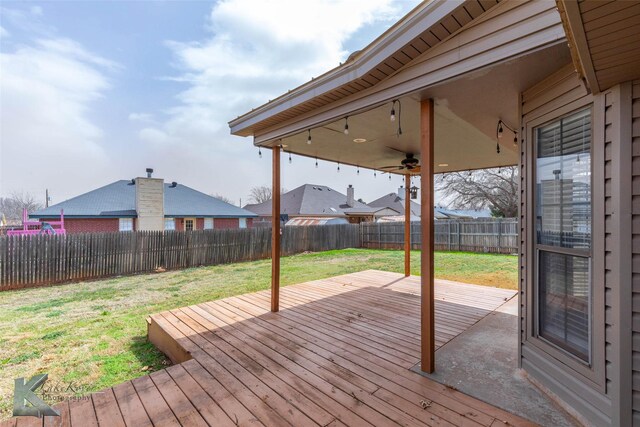 deck with a lawn and a fenced backyard