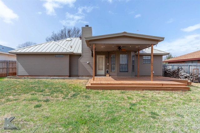 back of house with a yard, metal roof, fence, and a ceiling fan