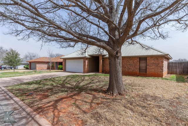 view of front facade with fence, concrete driveway, and brick siding