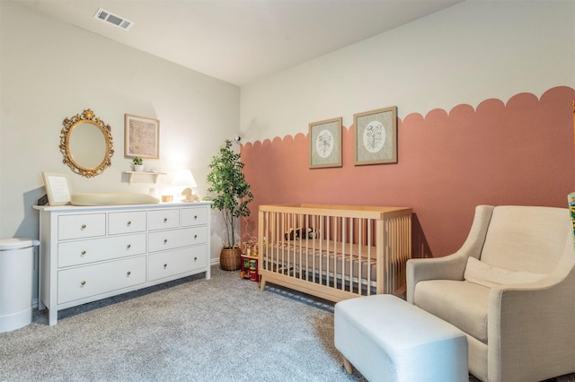 carpeted bedroom featuring a crib, baseboards, and visible vents