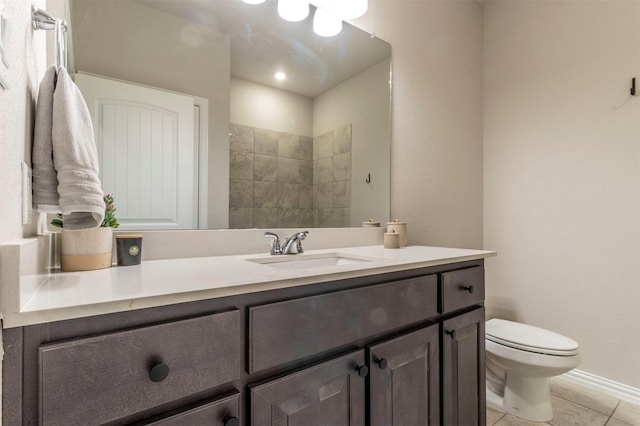 bathroom featuring baseboards, vanity, toilet, and tile patterned floors