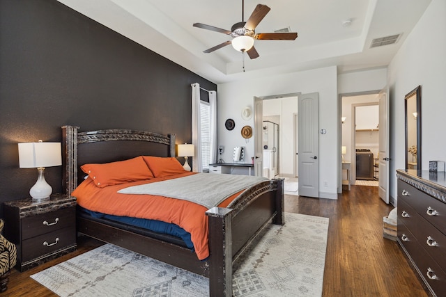 bedroom featuring wood finished floors, a raised ceiling, and visible vents