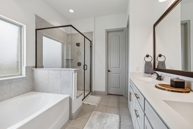 bathroom featuring a garden tub, double vanity, a stall shower, a sink, and tile patterned flooring