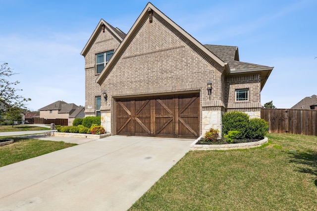 view of front of house featuring brick siding, an attached garage, fence, driveway, and a front lawn