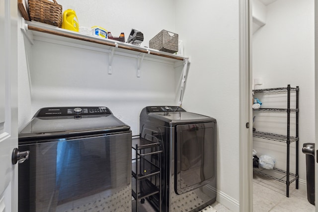 clothes washing area featuring washer and dryer, laundry area, and baseboards