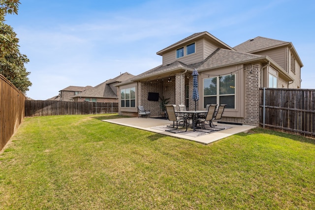 back of property featuring a fenced backyard, a patio, a lawn, and brick siding