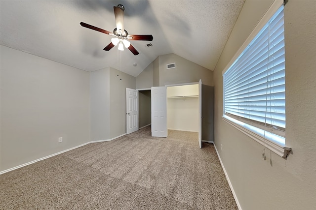 unfurnished bedroom with light colored carpet, a ceiling fan, baseboards, vaulted ceiling, and visible vents