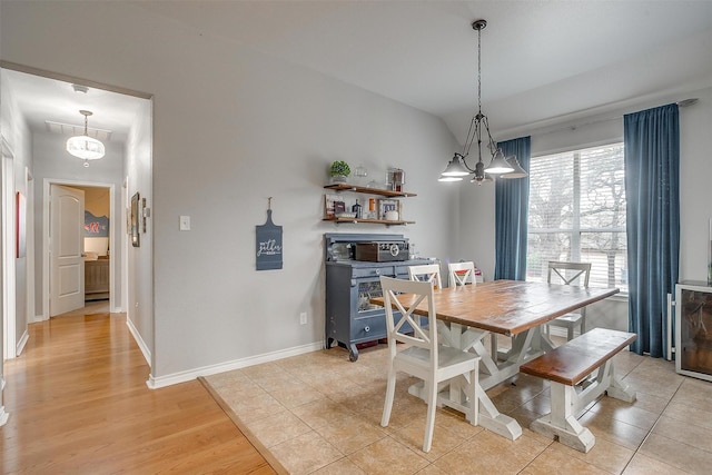 dining space with lofted ceiling, light wood finished floors, visible vents, and baseboards