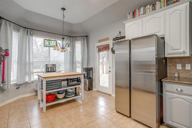 kitchen with white cabinetry, plenty of natural light, freestanding refrigerator, and decorative backsplash