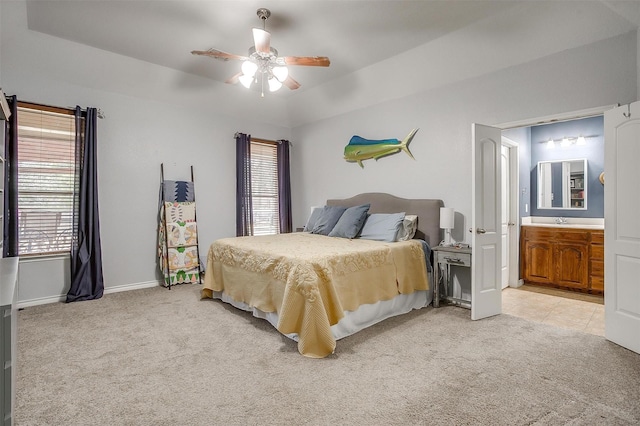 bedroom with light carpet, a sink, and multiple windows