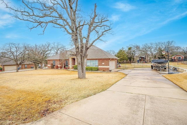 view of front facade featuring a garage, brick siding, fence, concrete driveway, and a front lawn