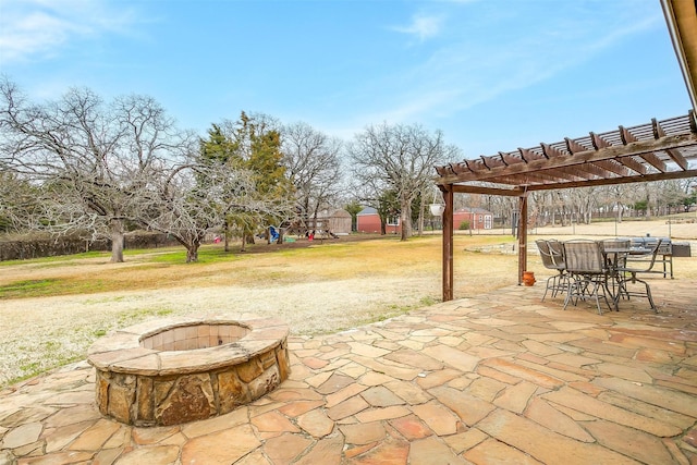 view of patio / terrace with an outdoor fire pit, outdoor dining area, and a pergola