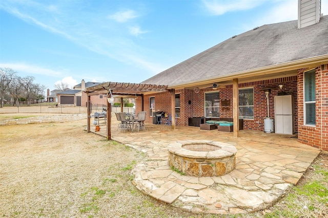 exterior space with an outdoor fire pit, a patio, roof with shingles, a pergola, and brick siding