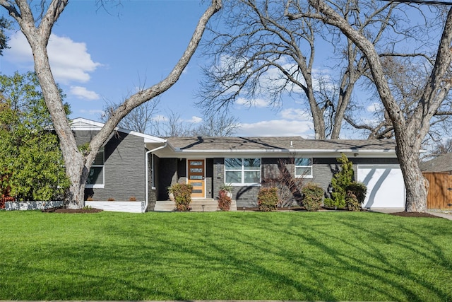 view of front facade featuring brick siding, a front yard, and fence