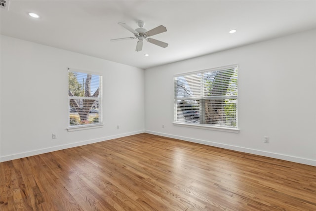 empty room with light wood finished floors, plenty of natural light, and baseboards