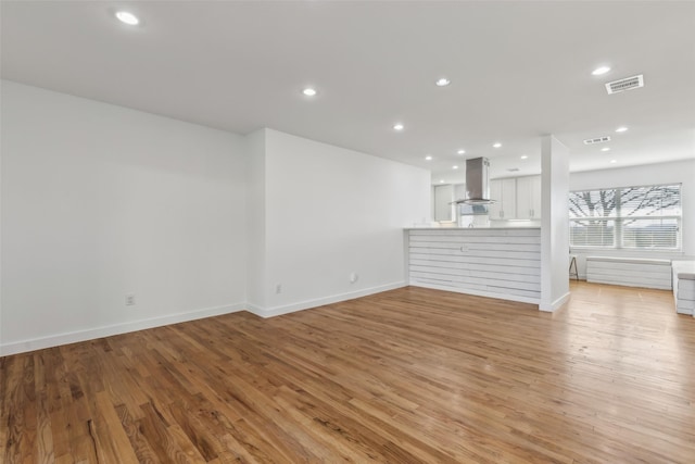 unfurnished living room featuring light wood-style floors, recessed lighting, visible vents, and baseboards