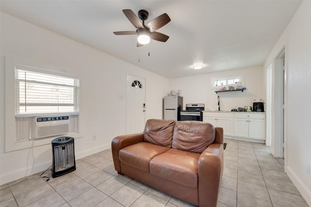 living area featuring light tile patterned floors, ceiling fan, baseboards, and cooling unit