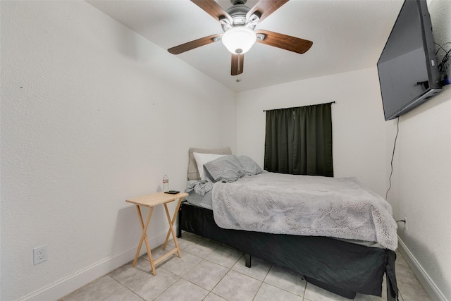 bedroom with light tile patterned floors, ceiling fan, and baseboards