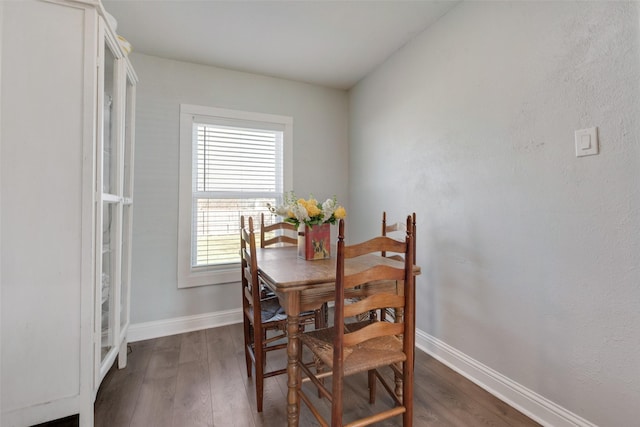 dining room with dark wood-type flooring and baseboards