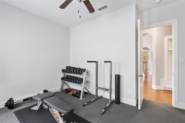 workout area with arched walkways, visible vents, baseboards, a ceiling fan, and carpet