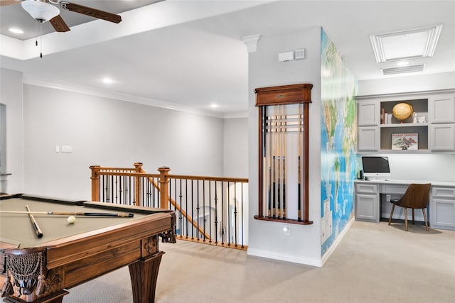 recreation room with light colored carpet, visible vents, baseboards, built in desk, and crown molding