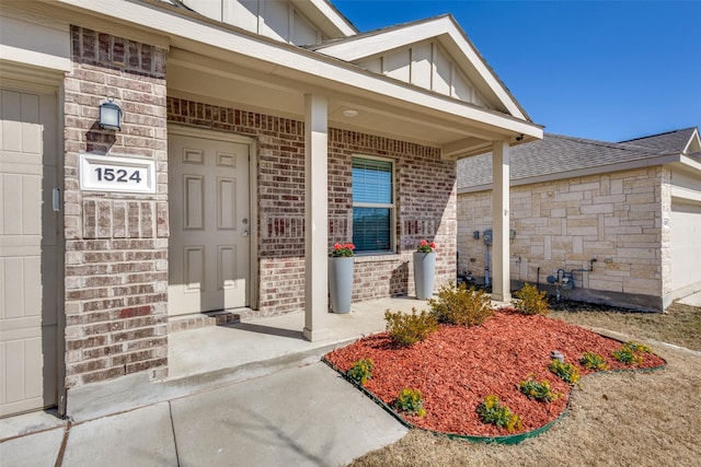 entrance to property featuring covered porch, brick siding, and board and batten siding