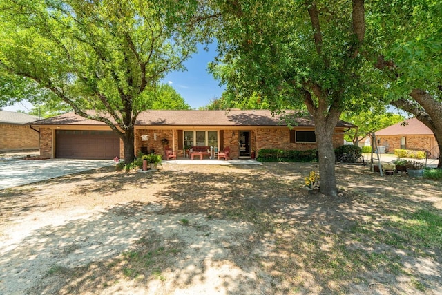 ranch-style house featuring a garage, driveway, and brick siding