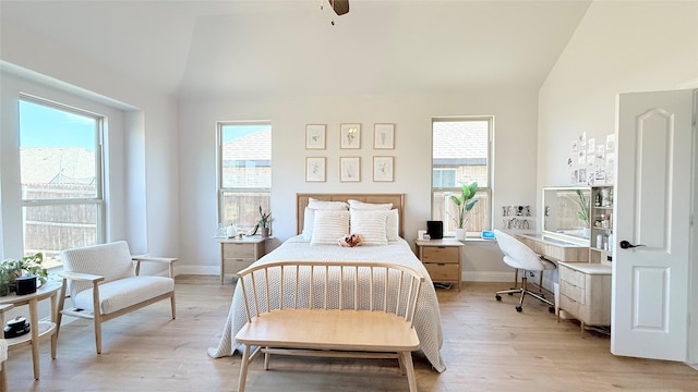 bedroom featuring lofted ceiling, light wood-style floors, ceiling fan, and baseboards