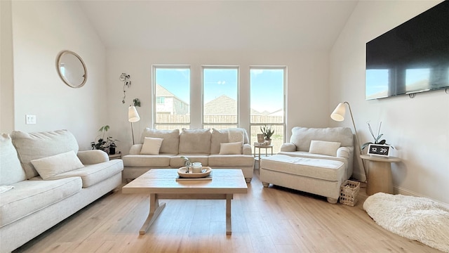 living area featuring light wood-style flooring and vaulted ceiling