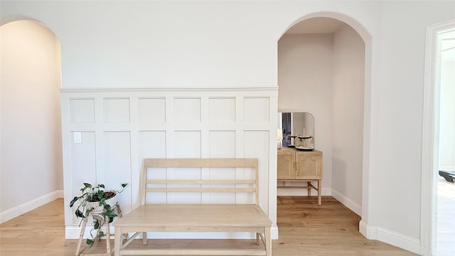 details featuring arched walkways, wood finished floors, and baseboards