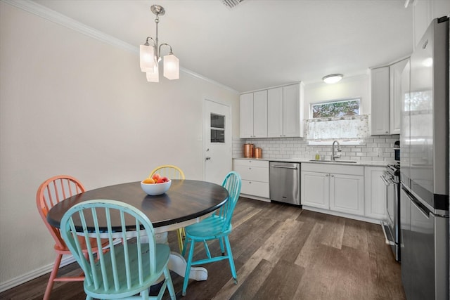 kitchen featuring appliances with stainless steel finishes, backsplash, a sink, and dark wood finished floors