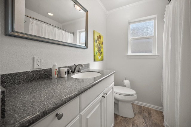 full bathroom featuring toilet, ornamental molding, vanity, wood finished floors, and baseboards