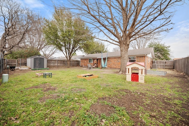 view of yard with central air condition unit, a fenced backyard, an outdoor structure, and a storage unit